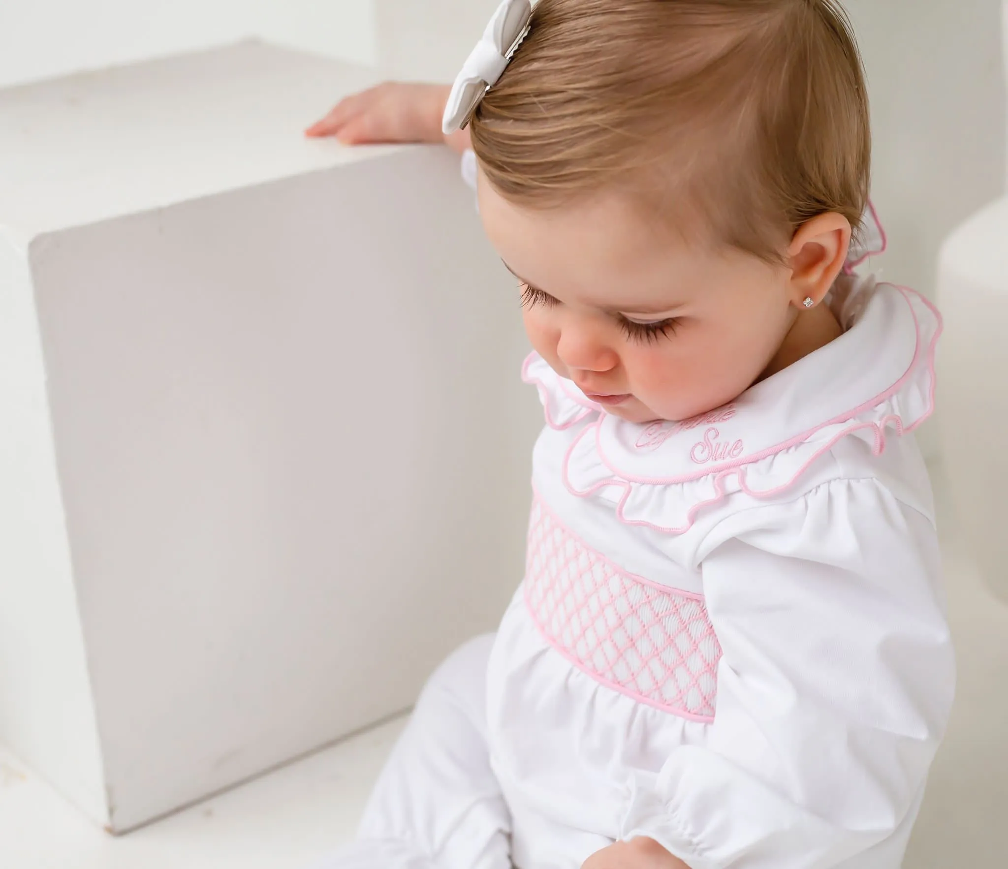 Girls smocked baby grow - white trimmed with pink