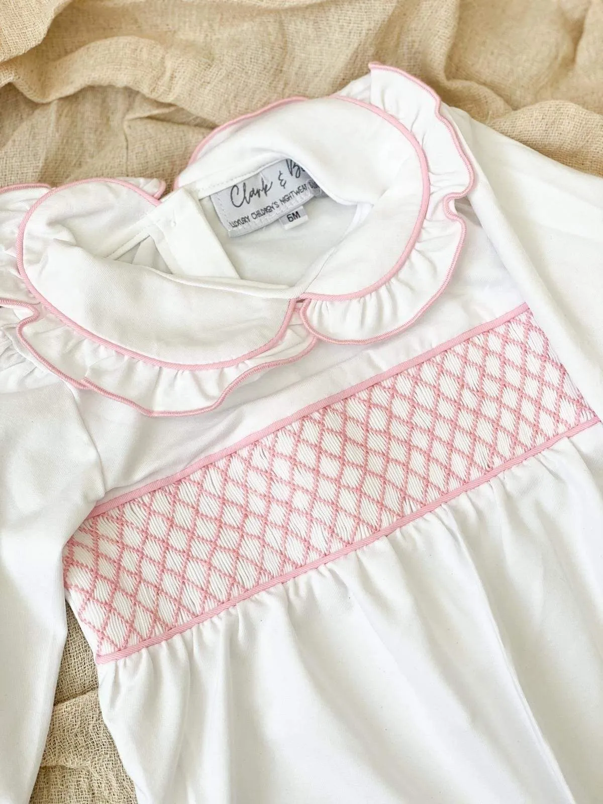 Girls smocked baby grow - white trimmed with pink